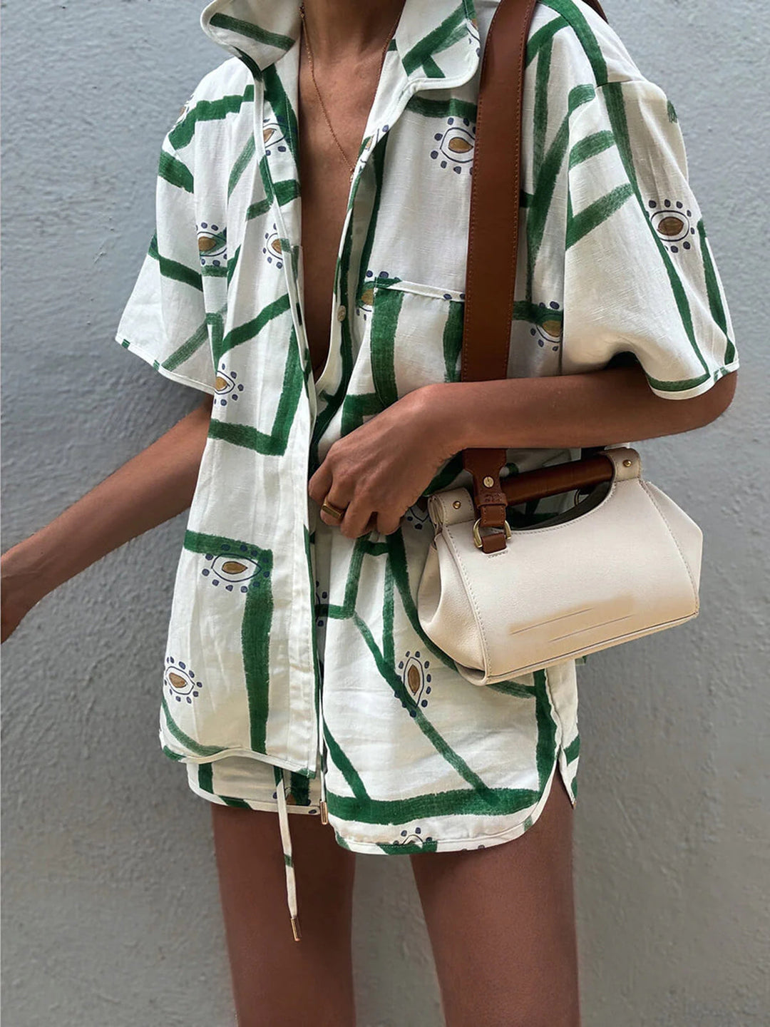 Set coordinato moda mare donna: camicia ampia e shorts con stampa geometrica vibrante.