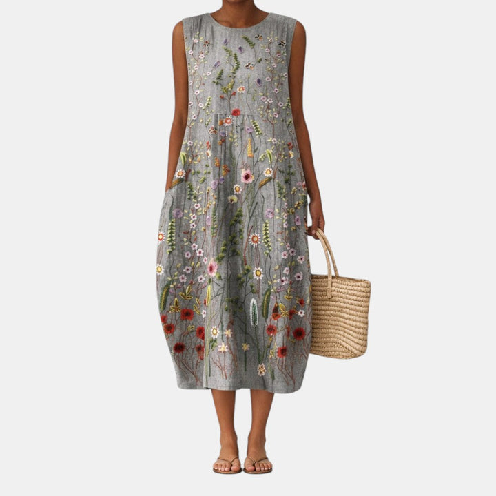 Elegante abito midi smanicato da donna con vivace stampa floreale botanica, ideale per look casual estivi.