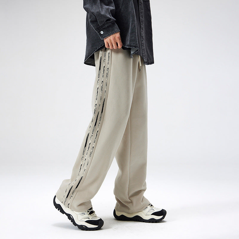 Uomo indossa pantaloni streetwear dritti con righe laterali. Perfetti per outfit casual comodi e di tendenza.