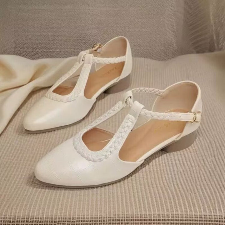 Scarpe eleganti donna nere con tacco basso. Punta affusolata e cinturini incrociati, ideali per comfort e stile classico.