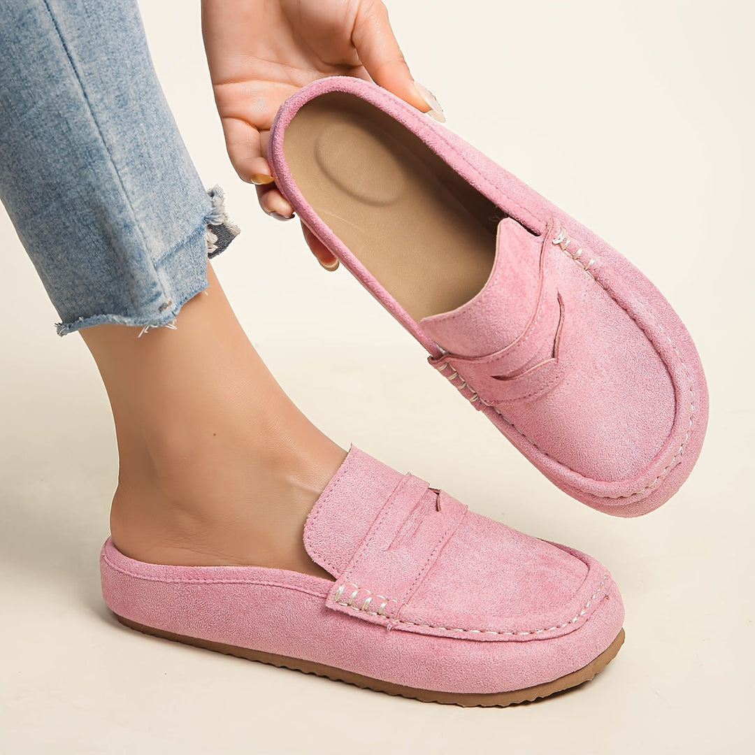 Sabot donna con plateau visti lateralmente, mostrando la suola rialzata e il design slip-on.