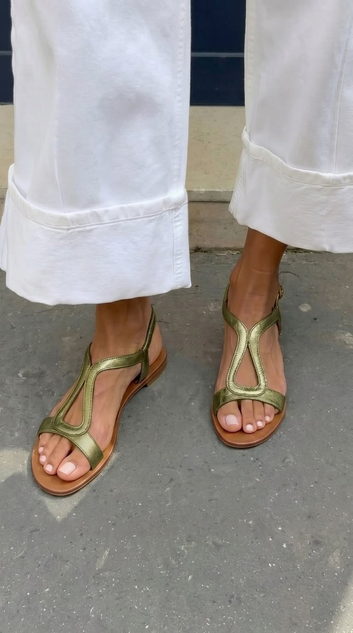 Sandali piatti donna metallizzati e aperti, con comodo cinturino, perfetti per giornate di sole e vacanze estive.
