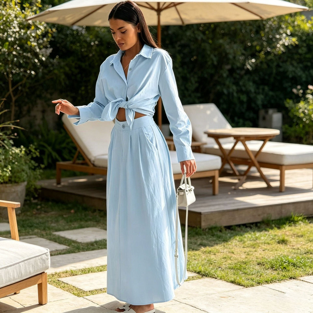 Gonna lunga fluida blu chiaro del set elegante donna, abbinata a blusa a maniche lunghe per un outfit raffinato.