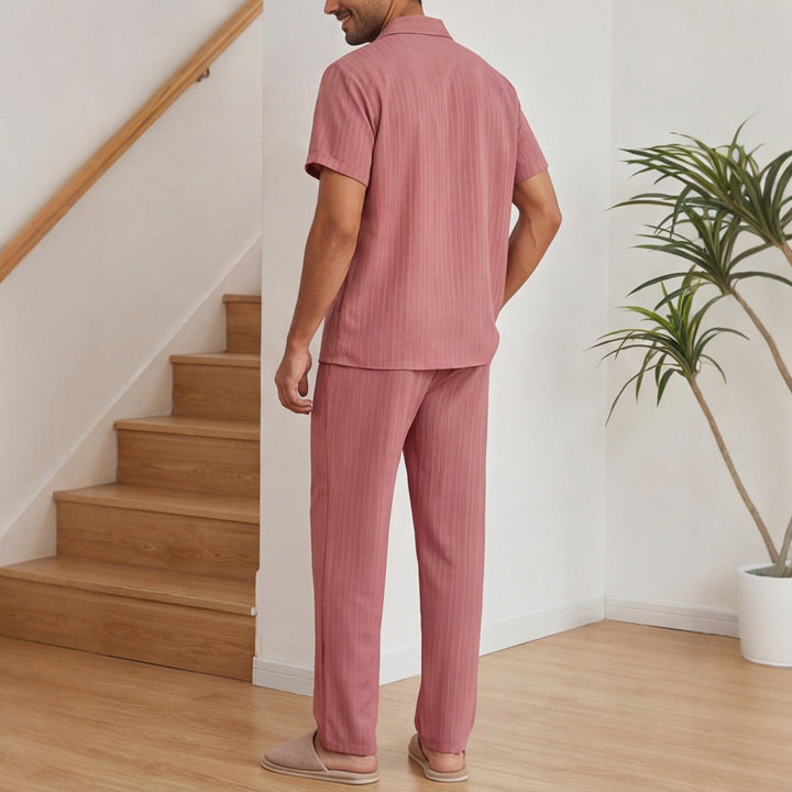 Set uomo due pezzi a righe rosa: camicia a maniche corte e pantaloni lunghi. Stile comodo e casual per il tempo libero.