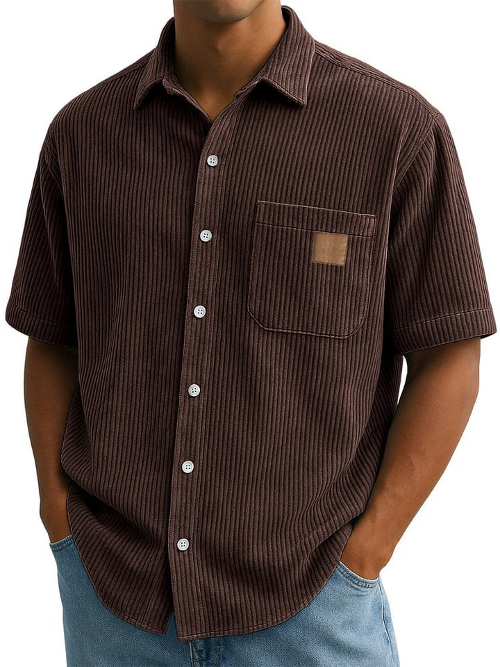 Camicia uomo a maniche corte con taschino effetto velluto. Vista frontale, stile casual estivo.