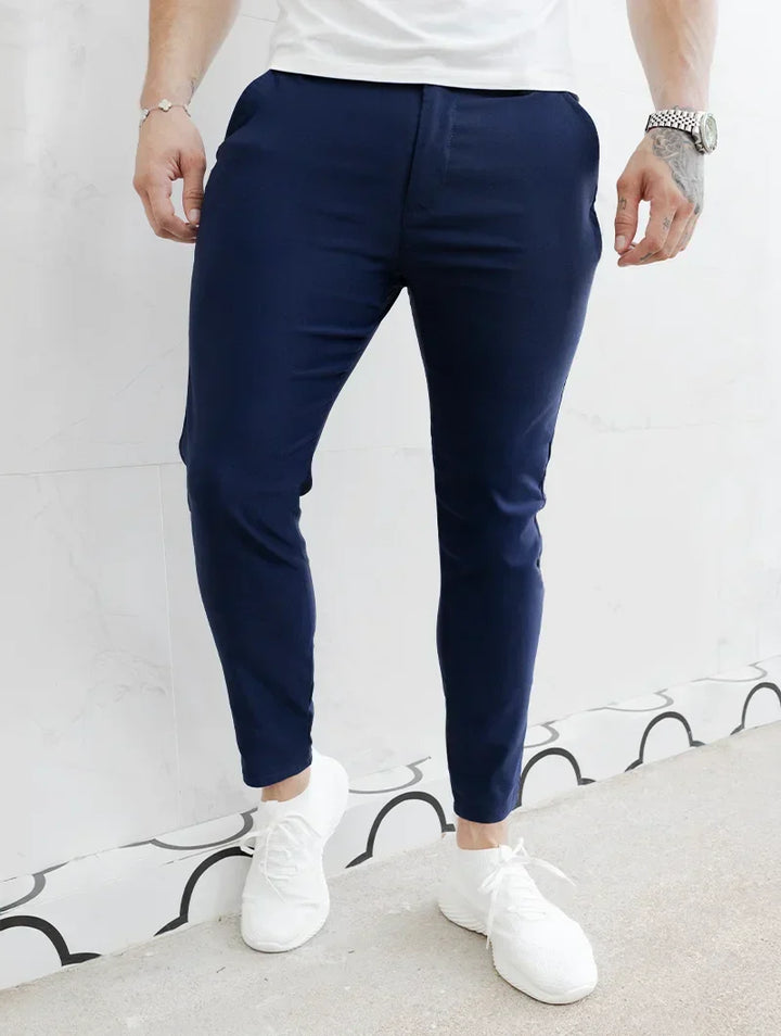 Uomo indossa pantaloni slim fit blu scuro elasticizzati, mostrando flessibilità e stile.