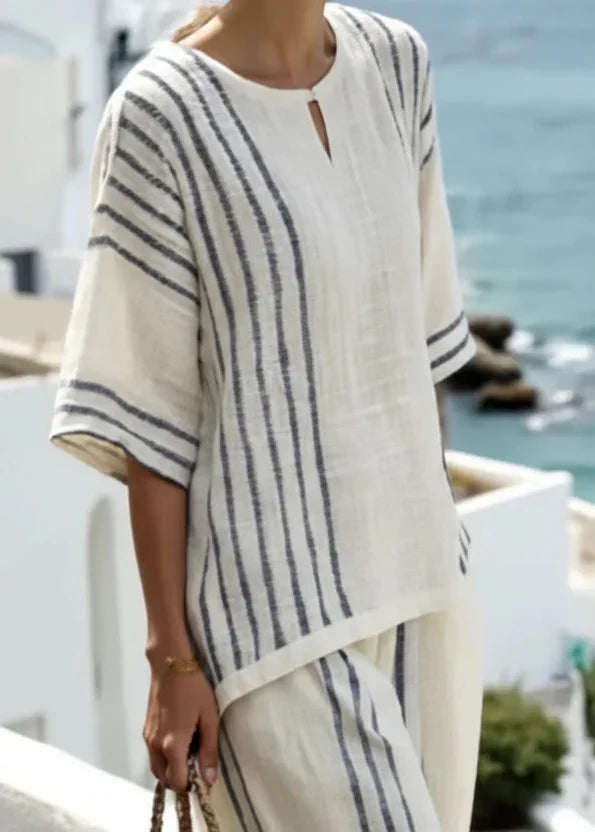 Outfit estivo donna: completo a righe con top senza maniche e pantaloni ampi e fluidi. Stile casual.