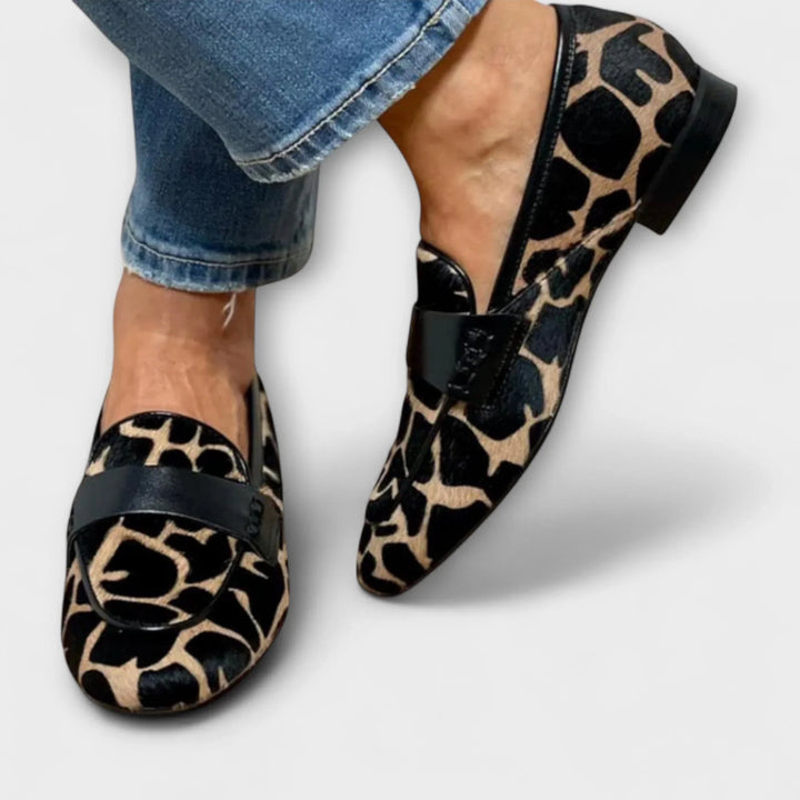 Scarpe mocassino donna con stampa animalier e fascia nera. Stile di tendenza e versatile per outfit quotidiani.