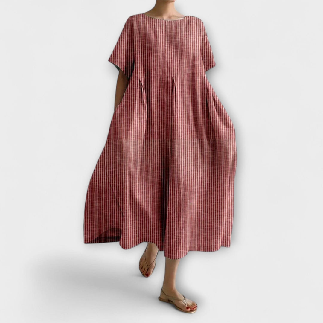 Vestito midi rigato oversize da donna con comode tasche e maniche a kimono, perfetto per un look estivo rilassato.