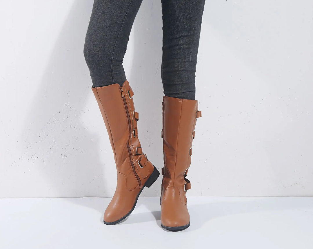 Stivali donna al ginocchio neri con fibbie decorative e tacco basso, ideali per un look elegante autunnale.