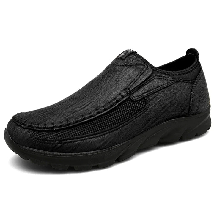 Comode scarpe uomo slip-on ortopediche, in pelle scura, ideali per passeggio, leggerezza e flessibilità.