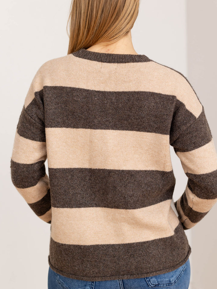 Modella indossa maglione girocollo a righe bloccate beige traforato, perfetto per un comfort quotidiano elegante.