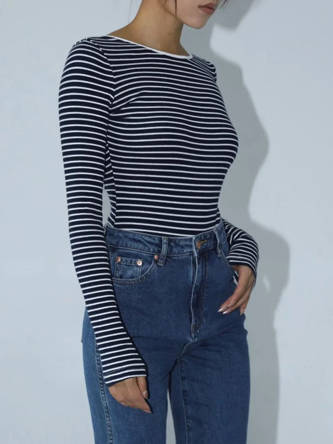 Top aderente body donna a righe, maniche lunghe, design sofisticato con schiena scoperta. Look versatile.