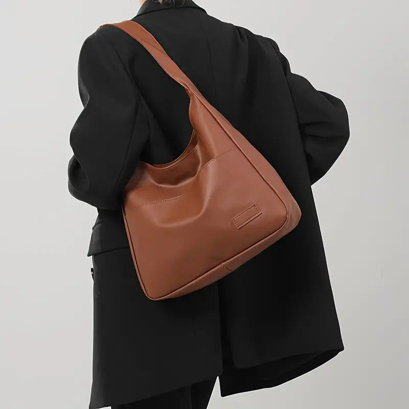 Borsa hobo nera da donna, design minimal e versatile, accessorio essenziale per un look casual e chic.