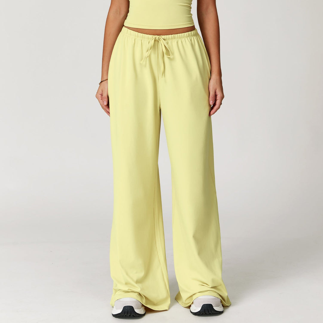 Pantaloni donna versatili larghi, vita alta, con dettaglio pendente. Ideali per abbigliamento sportivo o look casual.