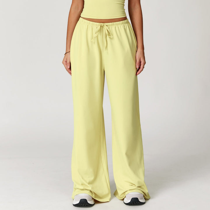 Pantaloni donna versatili larghi, vita alta, con dettaglio pendente. Ideali per abbigliamento sportivo o look casual.