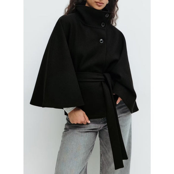 Donna indossa cappotto a mantella invernale con collo alto, look versatile per un abbigliamento femminile chic.