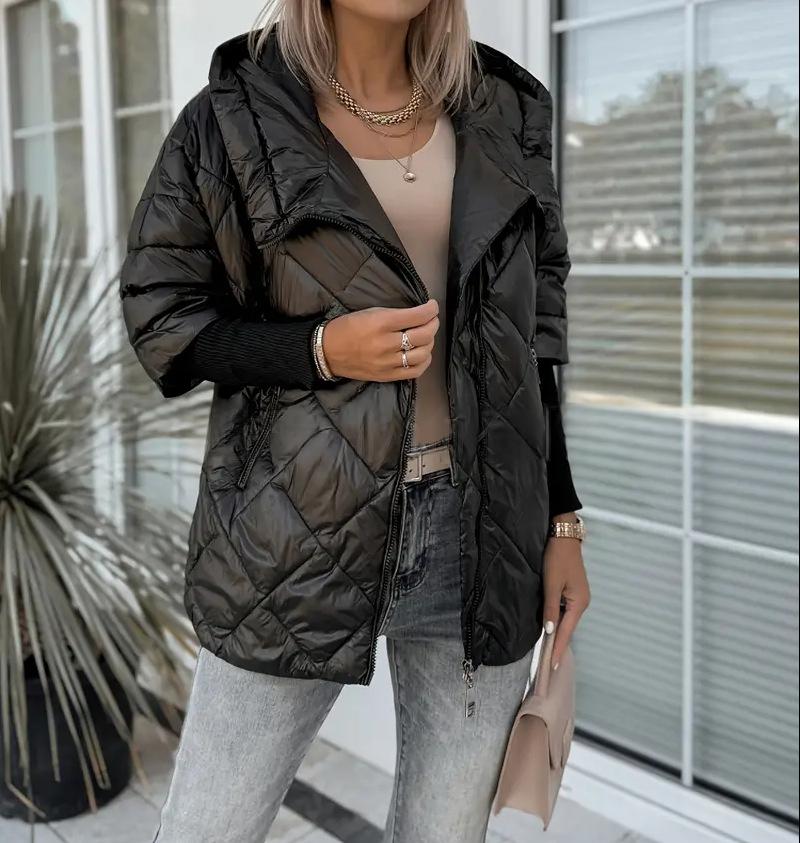 Piumino donna moda invernale: giacca puffer con cappuccio, zip e dettagli patchwork. Versatile e chic.