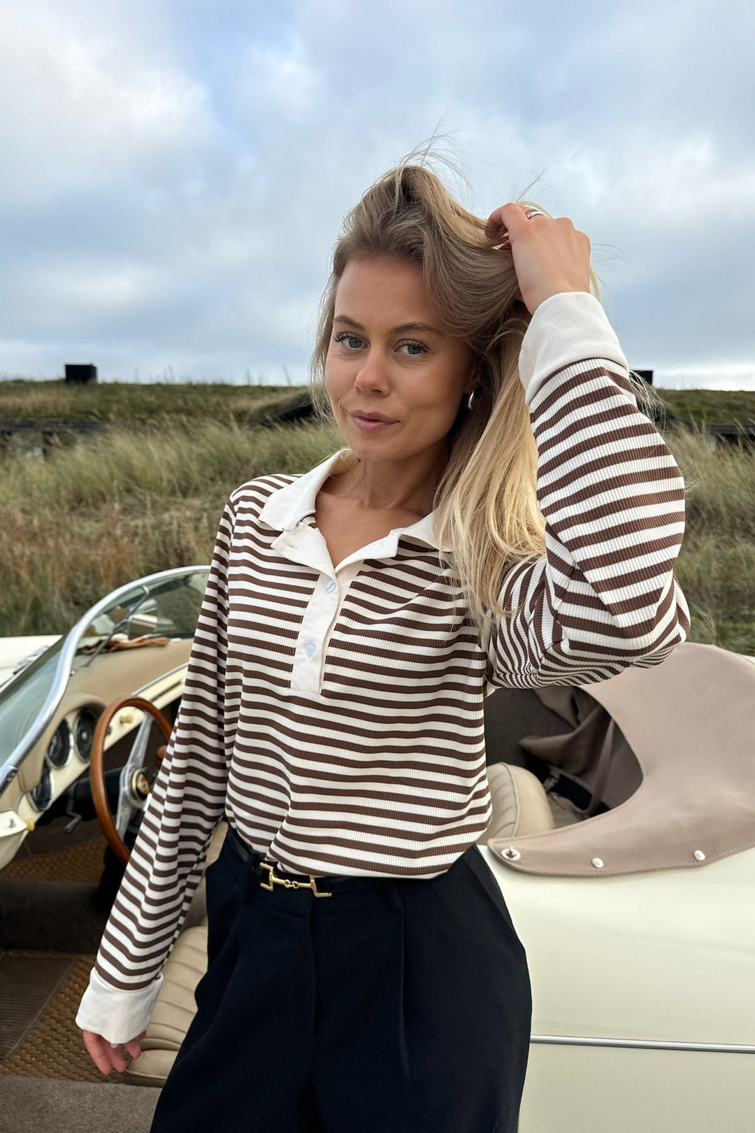 Polo donna elegante a righe marroni e beige, maniche corte, ideale per un look casual chic estivo.
