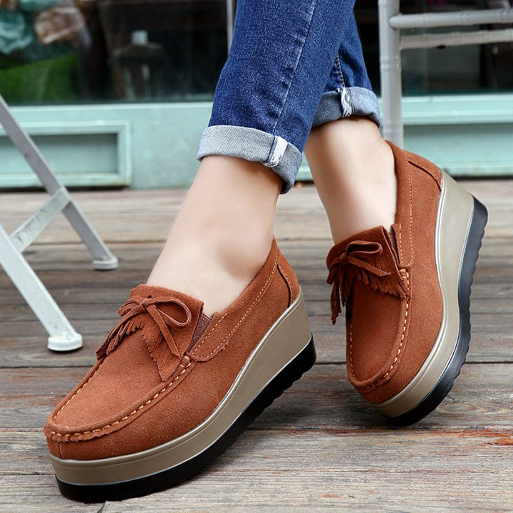 Mocassini donna slip-on con zeppa alta, fiocco decorativo e nappine per un look elegante.