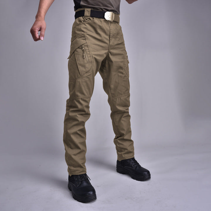 Uomo con pantaloni cargo multitasche per escursioni. Funzionali, impermeabili, per outdoor autunnale.