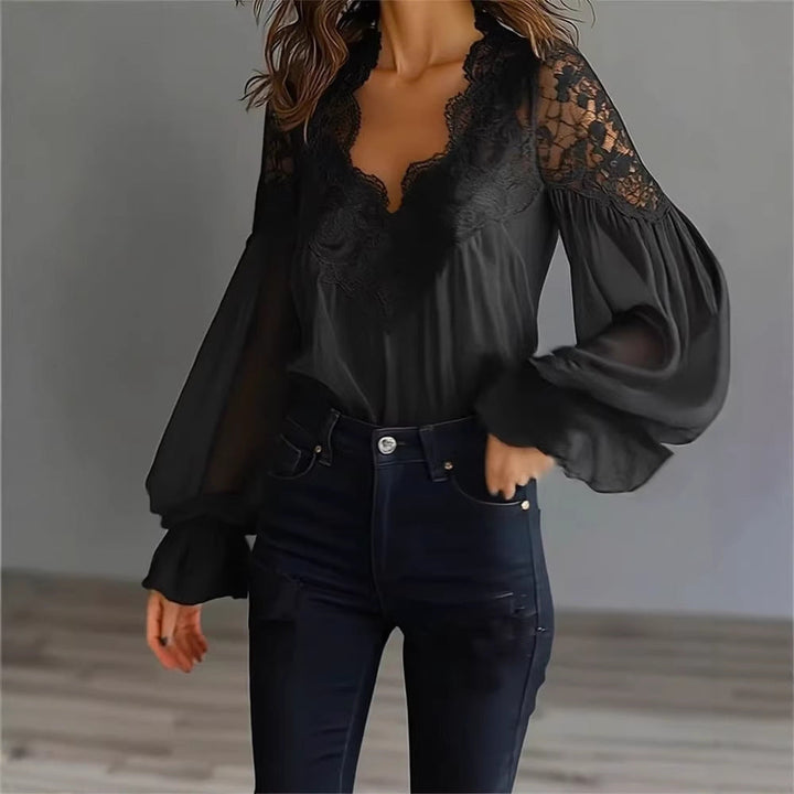 Moderna camicia donna con maniche lunghe, pizzo floreale e volant sulle spalle. Ideale per un look sofisticato ed elegante.