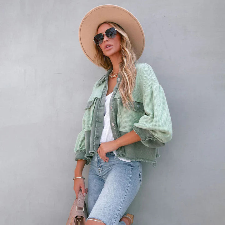 Dettaglio orlo sfrangiato di una giacca corta donna aderente, che esalta lo stile trendy casual.
