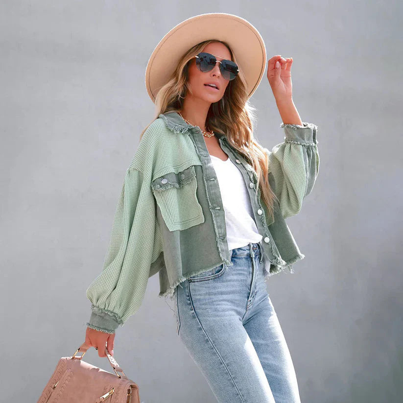 Vista frontale giacca corta donna, con design aderente e orlo sfrangiato, perfetta per look casual e trendy.