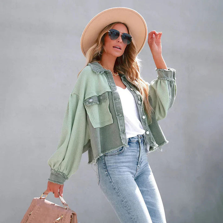 Vista frontale giacca corta donna, con design aderente e orlo sfrangiato, perfetta per look casual e trendy.