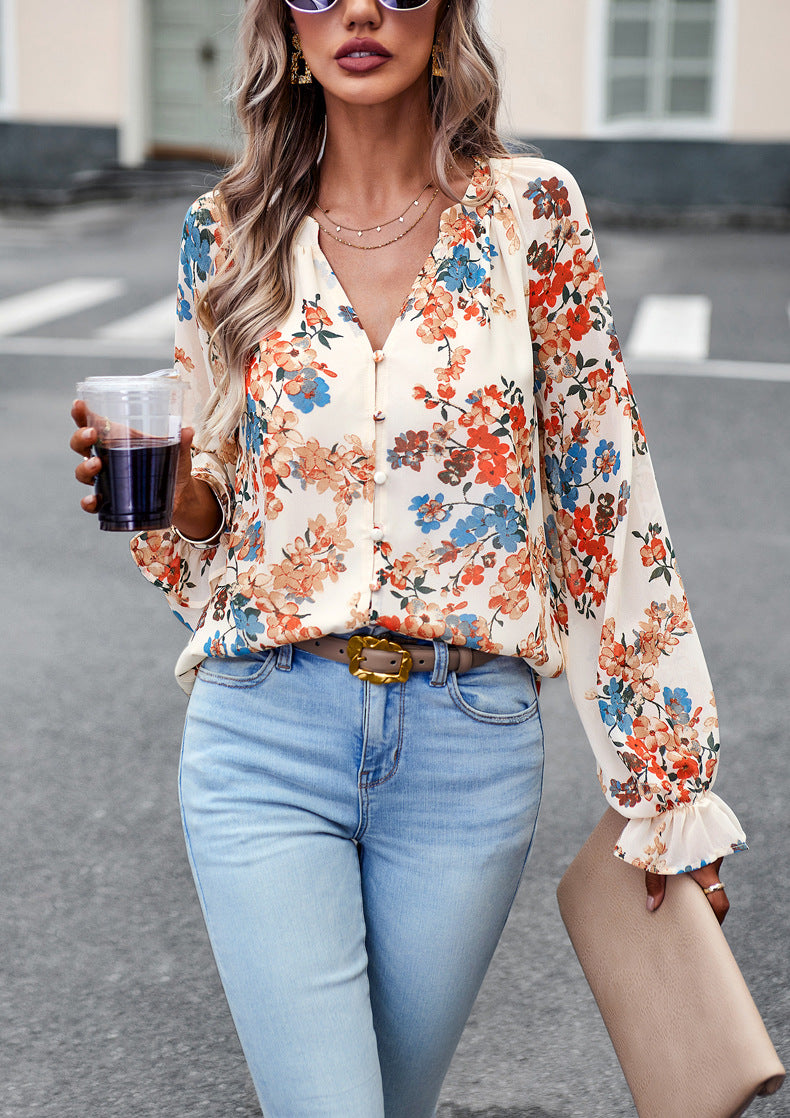 Primo piano blusa floreale donna, maniche lunghe e scollo a V. Dettagli floreali autunnali per un tocco chic.
