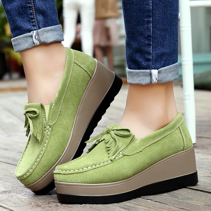 Mocassini donna slip-on zeppa, fiocco e nappine. Ideali per look casual ed elegante con comfort.