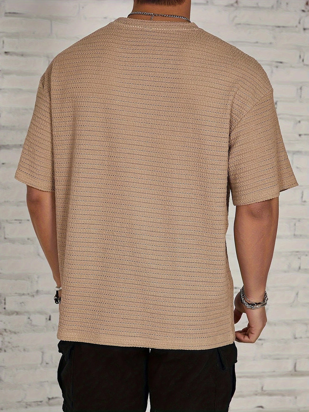 Maglietta uomo estiva a maniche corte, con texture moderna e stile rilassato per un outfit casual.