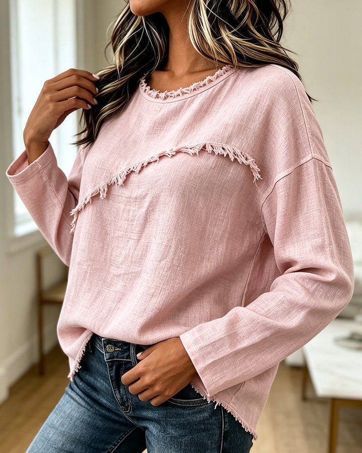 Blusa rosa da donna, vestibilità ampia con frange e taglio asimmetrico, ideale per outfit casual eleganti primavera.