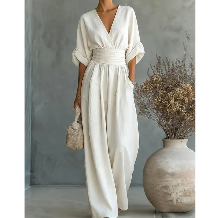 Modello di tuta intera rossa per donna, scollo a V e pantaloni ampi. Abbigliamento versatile.