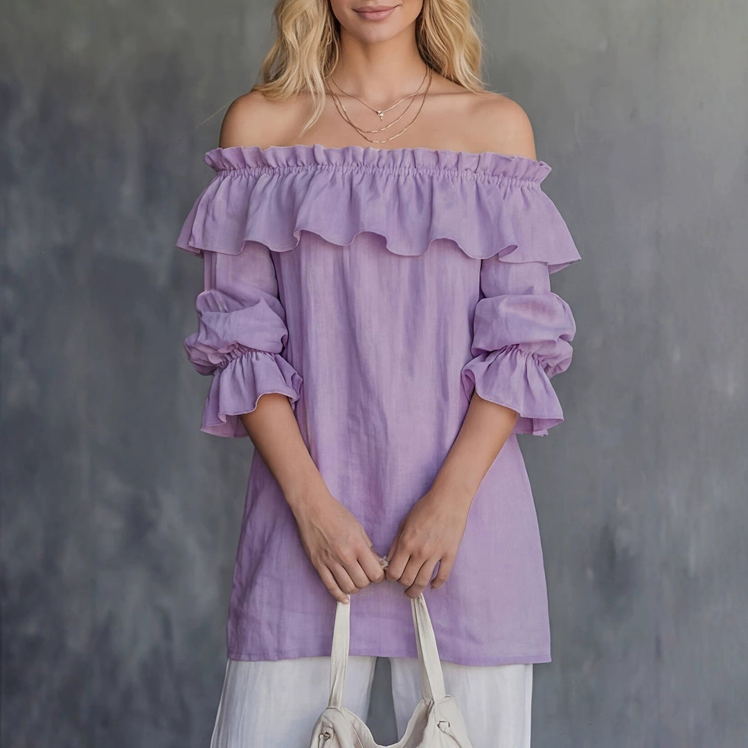 Dettaglio blusa donna: volant delicati e ampie maniche a sbuffo sul modello monospalla, per eleganza estiva.