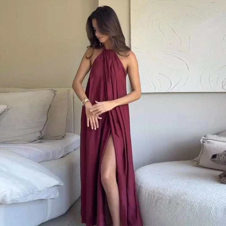 Elegante abito da sera maxi bordeaux con scollo halter e drappeggio, perfetto per eventi formali.