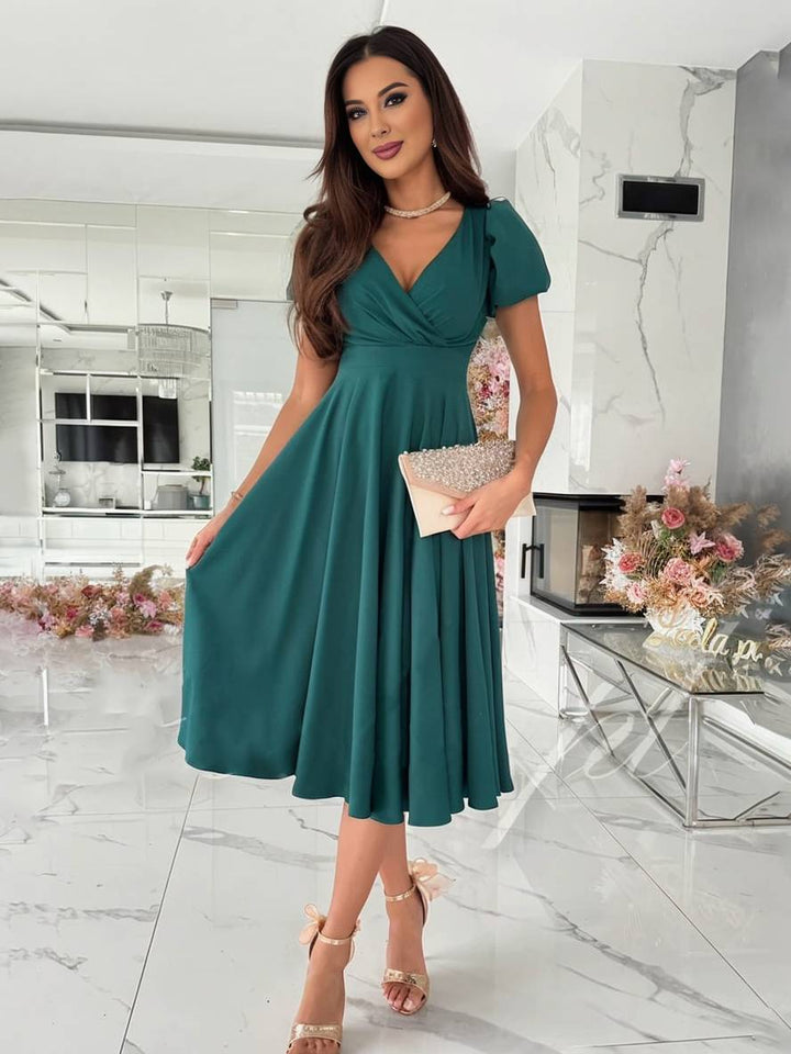 Abito da cerimonia midi, elegante e svasato, con maniche a sbuffo che esaltano la femminilità.