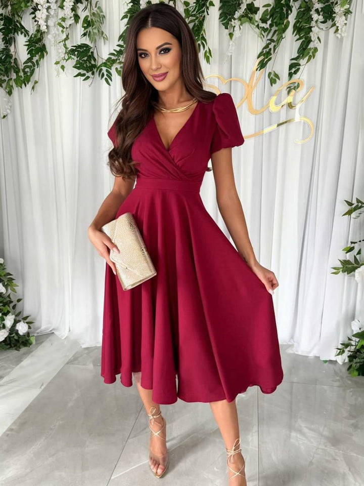 Modello abito midi svasato con maniche a sbuffo, ideale per la donna elegante e alla moda.