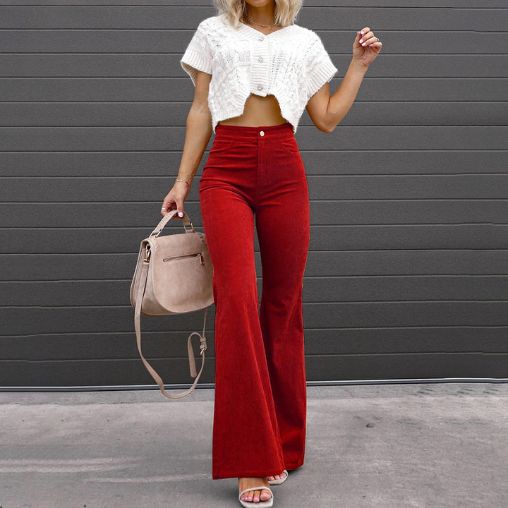 Donna che indossa pantaloni a zampa vita alta neri, abbinati per un outfit elegante e versatile.
