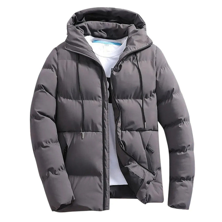 Giacca piumino uomo grigia trapuntata, ideale per l'inverno. Calda, antivento e con cappuccio per stile casual.