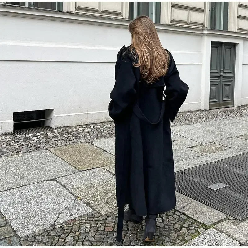 Cappotto lungo invernale da donna nero, dal taglio elegante che avvolge con stile e calore. Abbigliamento chic.