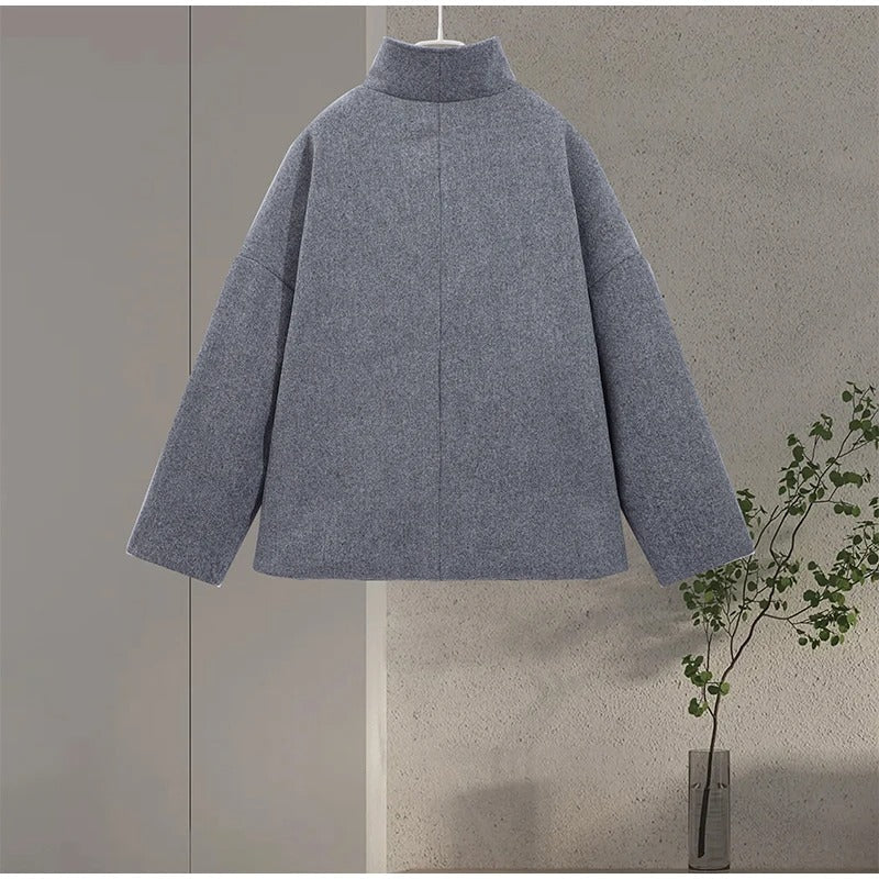 Primo piano del collo alto di un elegante cappotto donna. Dettagli raffinati e bottoni distintivi.