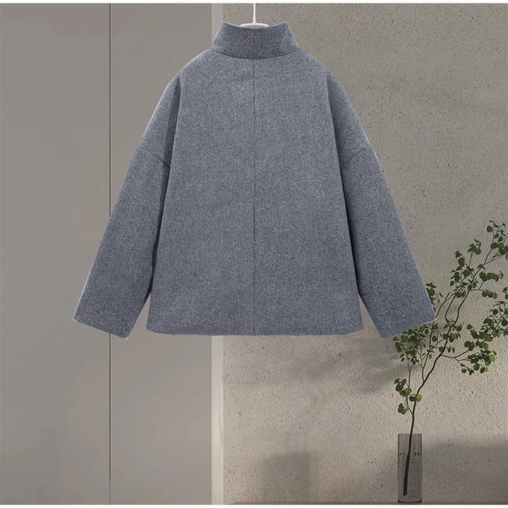 Primo piano del collo alto di un elegante cappotto donna. Dettagli raffinati e bottoni distintivi.