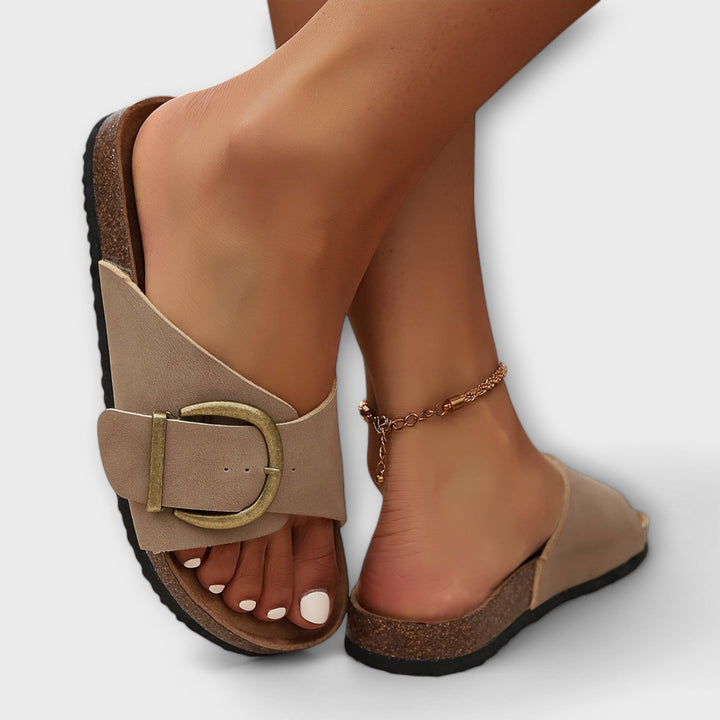 Vista laterale ciabatte donna con cinturini incrociati e fibbia dorata. Comode per moda mare e estive.