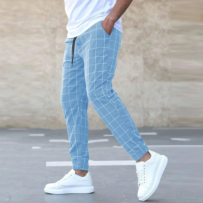 Jogger uomo a quadri blu e nero, vita elasticizzata. Pantaloni affusolati ideali per look streetwear sportivi.