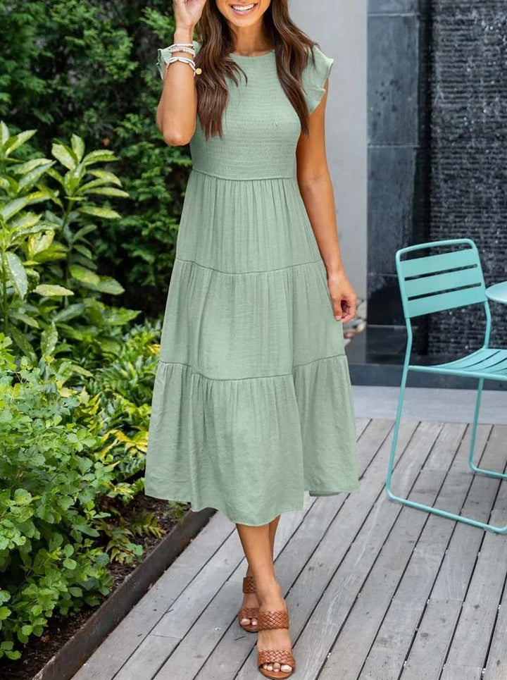 Abito midi rosa estivo, maniche a farfalla, ideale per un look fresco e alla moda in primavera.