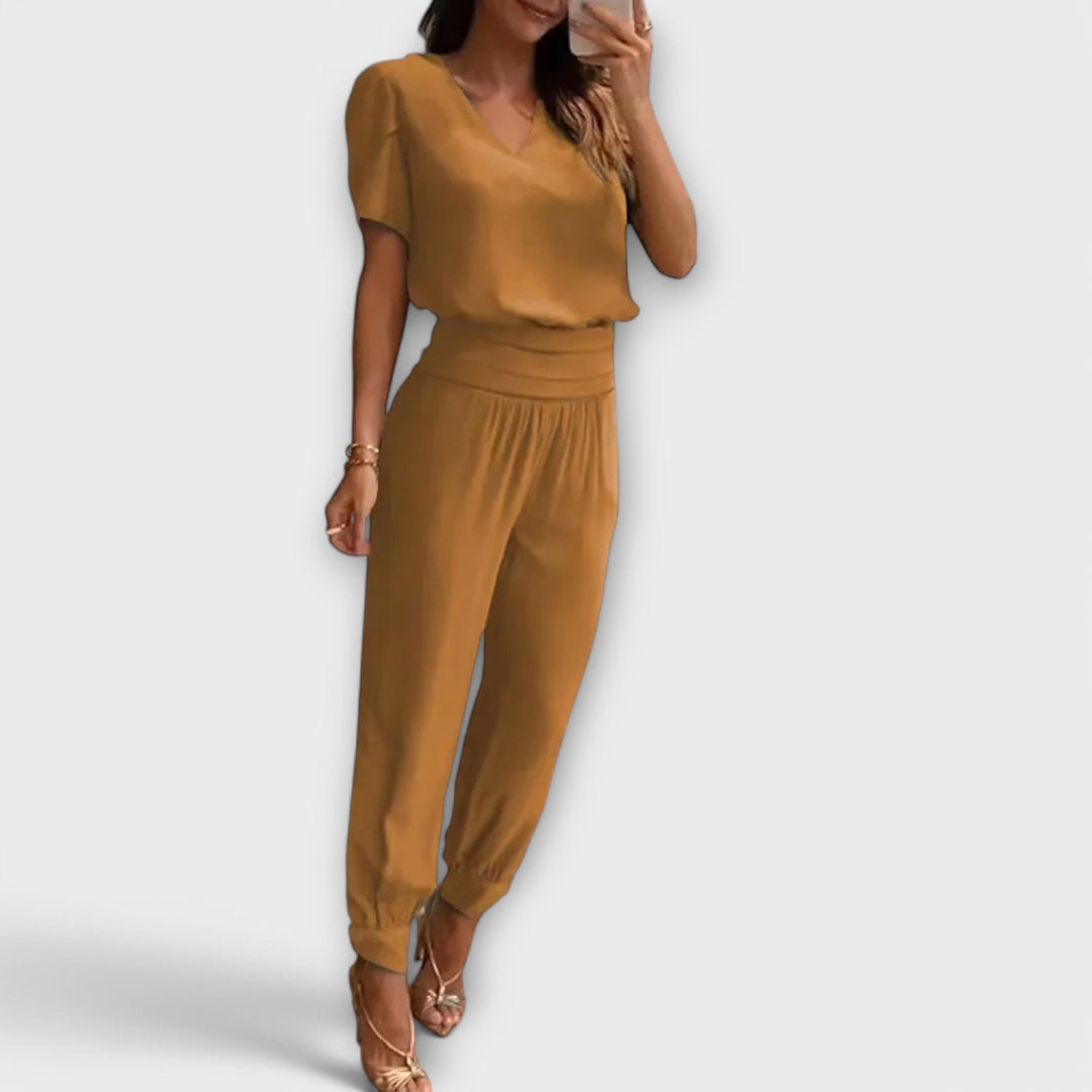 Donna in completo elegante fluido: top coordinato e pantaloni ampi. Perfetto per un look versatile e confortevole.