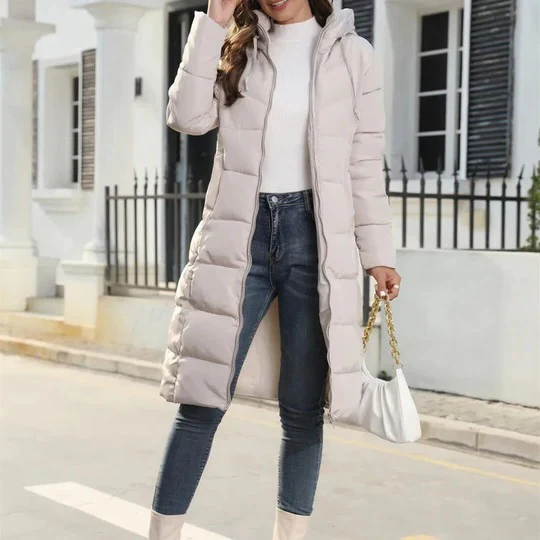 Piumino lungo donna invernale con cappuccio, caldo ed elegante, perfetto per outfit moda autunno inverno.