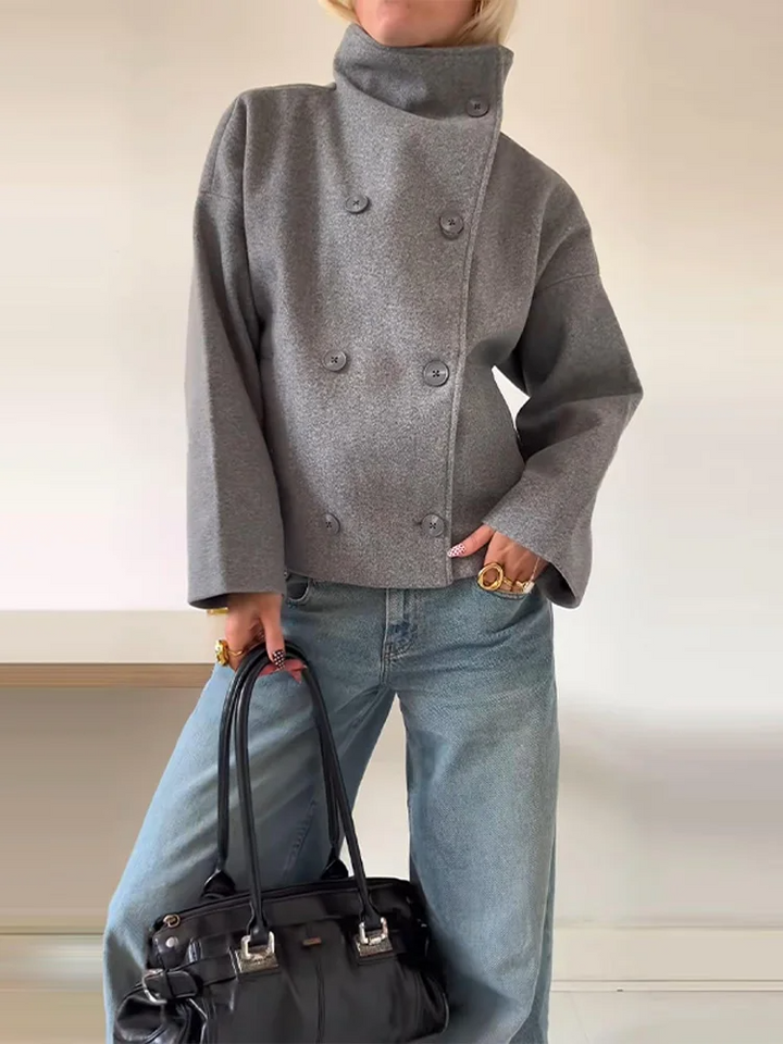 Cappotto donna nero invernale, collo alto e bottoni. Stile chic e caldo, adatto a diverse occasioni.