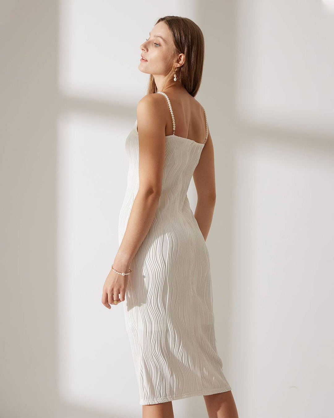 Abito donna midi elegante con perle, tessuto ondulato. Look chic per cerimonia, moda donna.